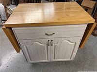 Front view of rolling kitchen island with butcher block tabletop and closed doors.