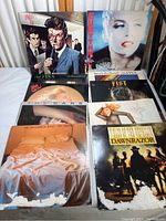 Overview of 9 vinyl records with album covers showing water damage and wear, with visible front album art including The Cars, Eurythmics, Fabulous Poodles, and others.