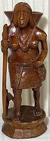 Front view of the wooden carved Indigenous woman standing figure showing detailed carving and staff.