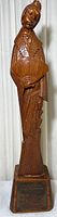 Full view of the tall wooden sculpture of a woman holding a fan, showing full body and base with carved details.