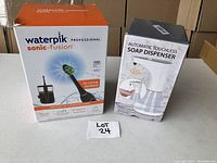 Box of Waterpik Professional Sonic-Fusion and box of Automatic Touchless Soap Dispenser on table