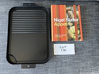 Photo showing both the grilling tray and Nigel Slater Appetite cookbook on grey fabric.