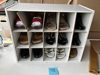 Shoe storage cabinet filled with various pairs of shoes showing style and condition.