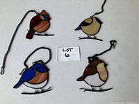 Set of four bird stained glass window hangings on a white background with LOT 6 label