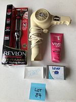 Lot with all items displayed: Revlon ceramic styling brush in box, beige hair dryer, L'Oreal Vive Pro conditioning treatment, two bars of soap (Zest and Lever 2000)