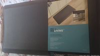Anti-fatigue kitchen mat in packaging with product label showing brand Living, mat dimensions 20 x 38 inches, dark gray.