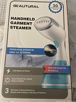 Front of the Beautural Handheld Garment Steamer box showing product image and key features like 1200 watts power, 30 second heat-up, auto shut-off, and 3 included attachments.