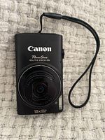 Front view of Canon PowerShot ELPH 330 HS camera showing lens and brand markings