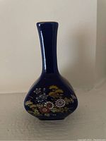 Front view of cobalt blue miniature vase with floral designs.