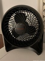 Front view of the black Honeywell fan showing the three blades and the logo at the center of the grille.