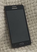 Front view of Samsung Galaxy Grand Prime SM-G530W cell phone with screen powered off.