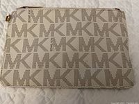 Front view of the beige pouch bag with MK monogram pattern
