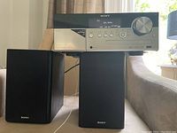 Sony stereo AM/FM radio unit with iPod/iPhone dock and paired speakers on either side.