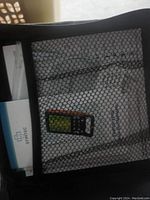 Closed carrying case with mesh front showing device and manuals inside.