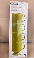 Box showing the set of four lime green stackable Stokes Chopes mugs, packaged vertically.