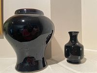 Photo showing both ceramic vases side by side, highlighting their size difference and black glazing