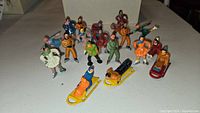 Photo showing 16 lead figures including skaters, sledders, and a skier arranged on a surface