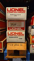 Stack of four Lionel train car boxes showing model numbers and branding.