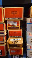 Stack of five boxed Lionel Electric Train model boxes clearly showing labels with individual model names and numbers