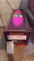 Box of MTH Alco DL-109 Diesel locomotive showing purple color, features and branding details on side and end of box.