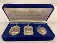 All three amulets displayed in blue velvet box