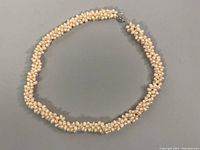 Full view of twisted beaded baroque and rice pearl necklace laid flat showing length and clasp.