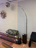 Full view of the large floor lamp with curved metal arm and black marble base, showing overall size and shape.