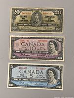 Front view of 1937 $20 bill, 1954 $10 and $5 bills showing front designs and portraits.