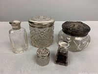 All five jars with lids arranged in two rows on white background