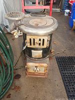 Front view of antique Crosley Rockland 802 stove showing metal top, door closed, and circular side shelf.