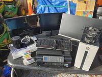 Photo of all items including monitors, printer, desktop, keyboard, and accessories on table with background objects.