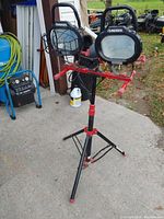 Husky dual head work light on tripod from side angle, showing the mounting and power cable