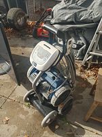 View of Polaris robotic pool cleaner power control unit mounted on storage cart with coiled cable and wheels