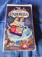 Front cover of the VHS case showing Cinderella and Prince Charming, with promotional stickers.
