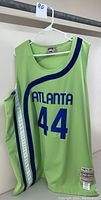 Front view of light green sleeveless Atlanta Hawks basketball jersey with blue and white stripes, number 44 and ATLANTA text.
