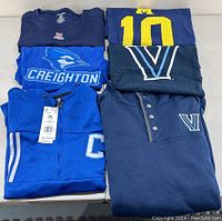 Overview of all 6 collegiate apparel items folded.