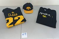 Full view of all three apparel items: Nike Clark 22 long sleeve T-shirt, Iowa Hawkeyes short sleeve T-shirt, and Iowa cap.