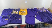 Photo of all LSU apparel laid out showing shirts, jacket, pants, and shorts.