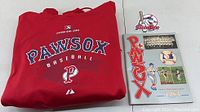Red Pawsox baseball hoodie folded next to the team patch and 1983 yearbook program