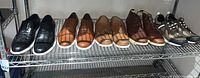 Shelf with six pairs of men's shoes in various styles and colors