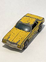 Yellow Monte Carlo Stalker #38 Hot Wheels car showing wear with chipped paint and intact Redline wheels