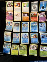 Photo showing a selection of Pokémon cards including Trainer cards Shauna, Great Ball, Potion, and Pokémon such as Misdreavus, Rufflet, Drilbur, Simipour, Snover, Feebas, and Slowpoke on a black background.