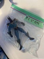 Batman figure in plastic bag with label indicating 5 inch, 1994