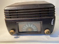 Front view of vintage General Electric radio receiver with dark Bakelite style casing, front tuning dial, and control knobs.