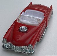 Red hot wheels convertible with chrome front and white interior, showing detailed front grill and raised engine in hood.