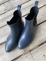 Top-down view of dark blue ankle rain boots with elastic side panels and pull tabs on back.