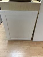 Photo of solid wood shaker style cupboard door panel in white finish, showing clean edges and flat panel style.