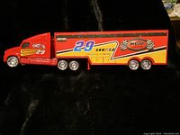 Side view of the red Motormax tractor trailer truck with race number decals and XGR logo on the trailer.