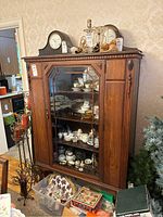 Front view of the wood china cabinet with glass door and visible interior shelves containing china items (not included in sale).