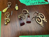 All four earring pairs arranged on wood surface with green label marking 14k